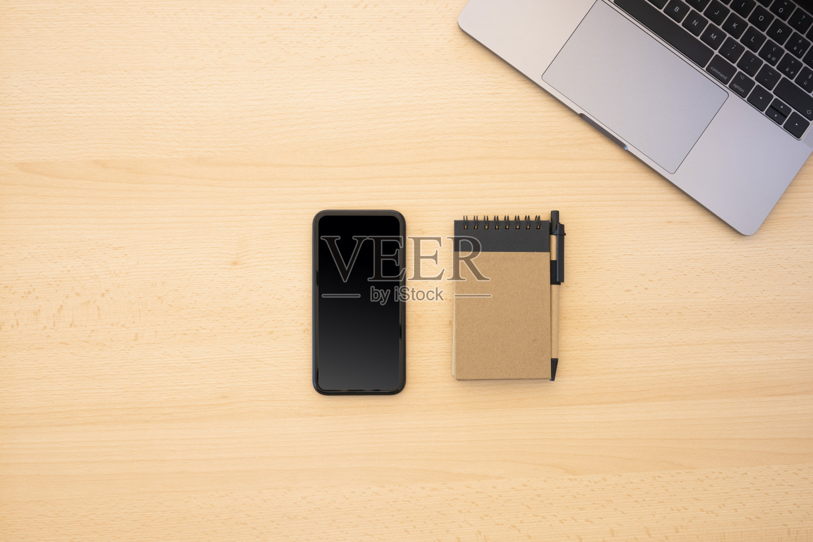 在Covid-19大流行期间，平躺与复印空间，在家工作的概念。木桌上摆放着智能手机、笔记本电脑和记事本。照片摄影图片