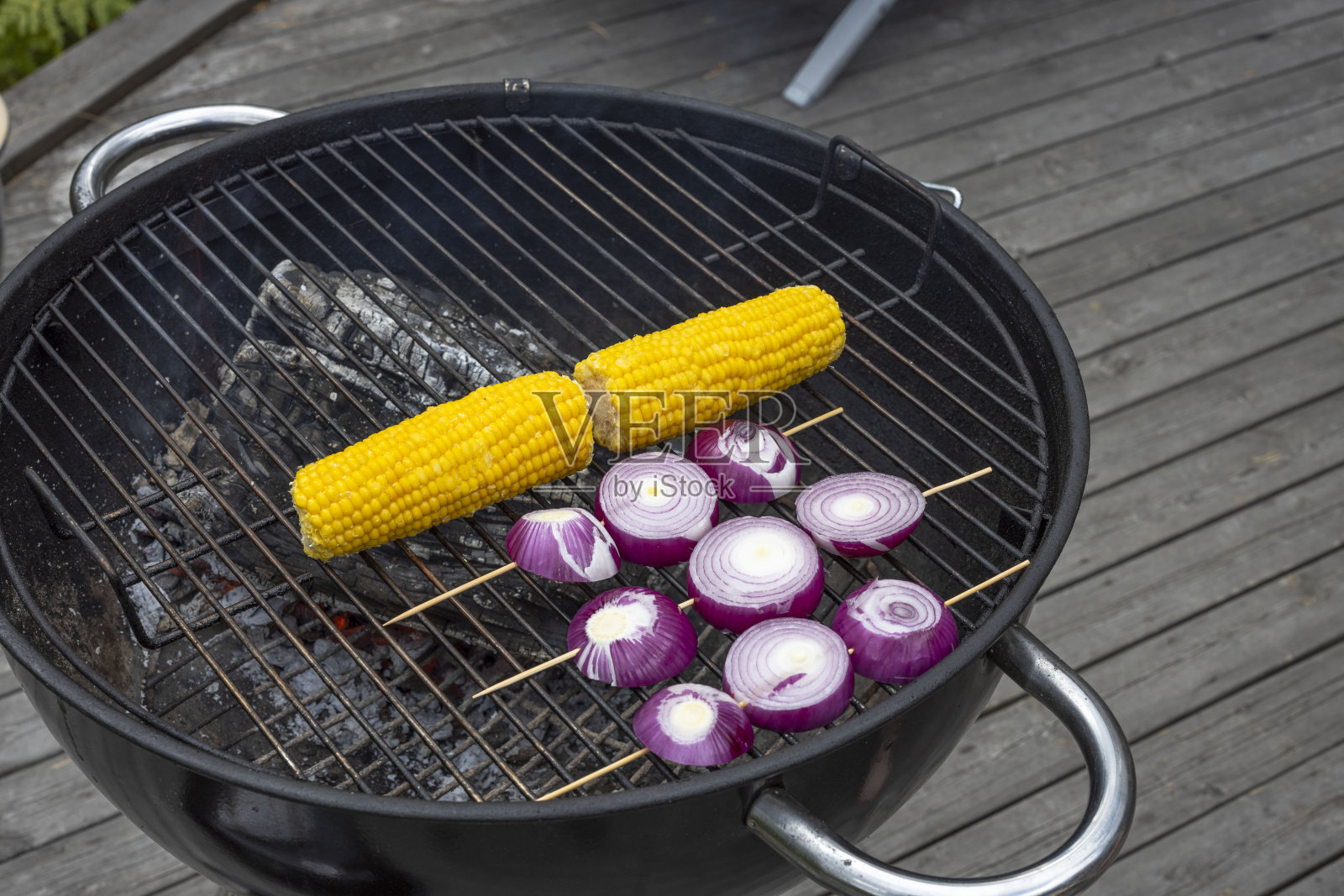 在一个夏天的户外烧烤玉米和洋葱的近视图。健康食品的概念。瑞典。照片摄影图片
