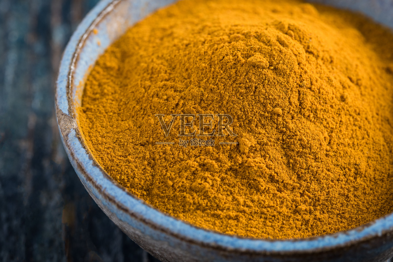 在碗里磨碎的姜黄根照片摄影图片