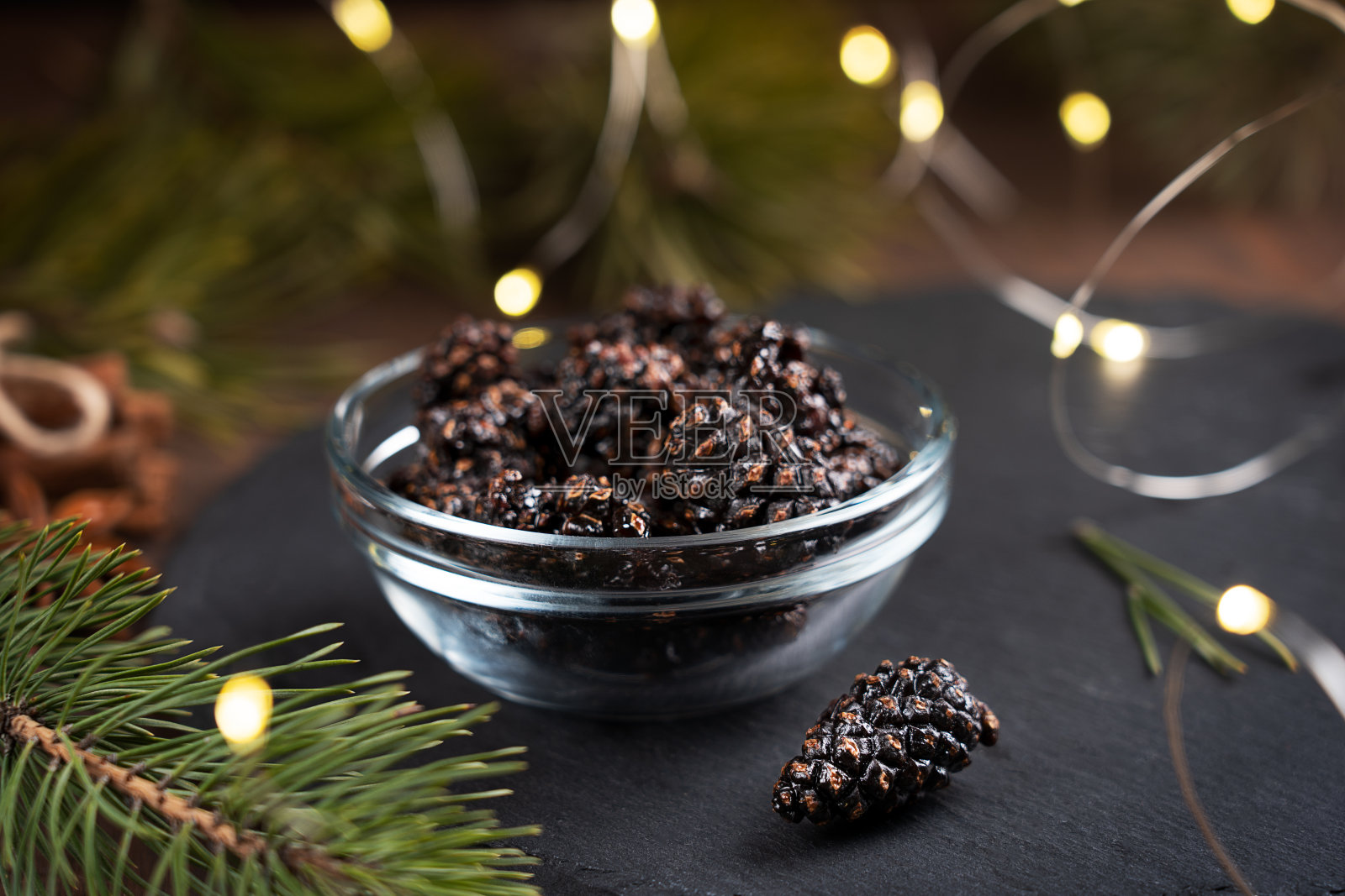 乾素松果罐头糖浆与花环灯和冷杉枝在碗照片摄影图片