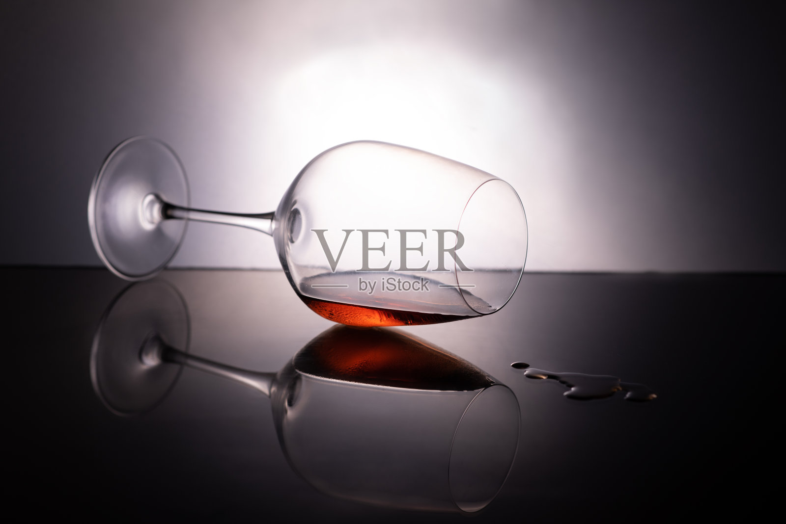 在黑色背景中滴着液体的一杯酒照片摄影图片