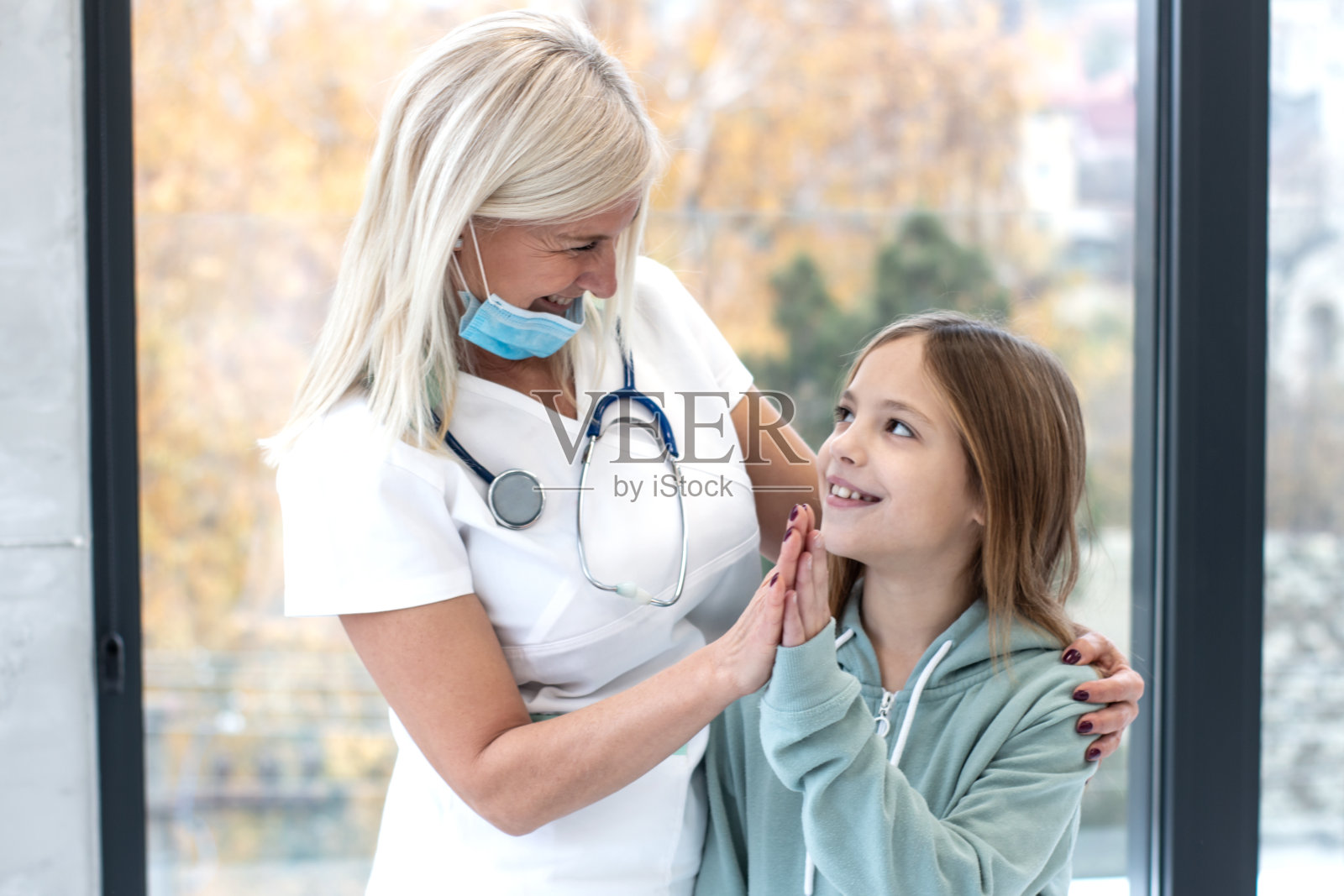 女医生微笑着和一个小女孩病人在医疗检查照片摄影图片