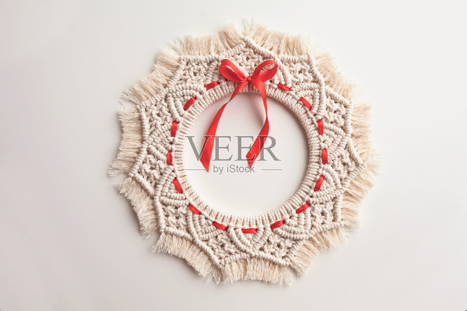 圣诞装饰。在白色的背景上为圣诞节和新年编织的花环。天然棉线，繁文缛节。生态装饰的家。照片摄影图片