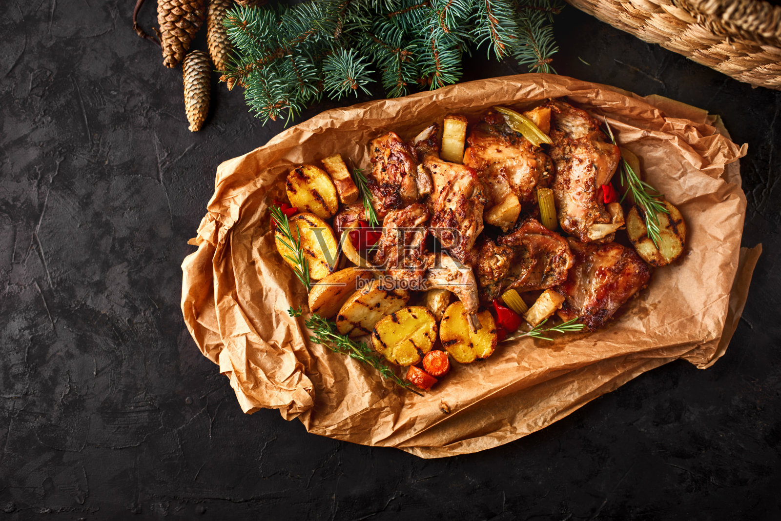 圣诞菜肴，烤兔肉和蔬菜特写在烤纸上的桌子上。照片摄影图片