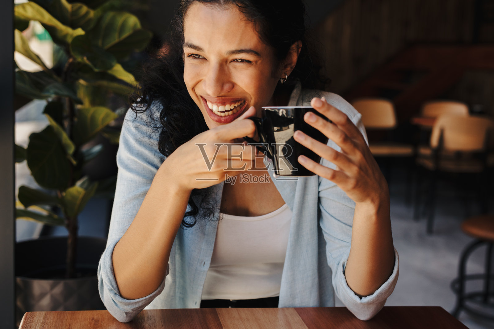 微笑的女人在咖啡馆享受咖啡照片摄影图片