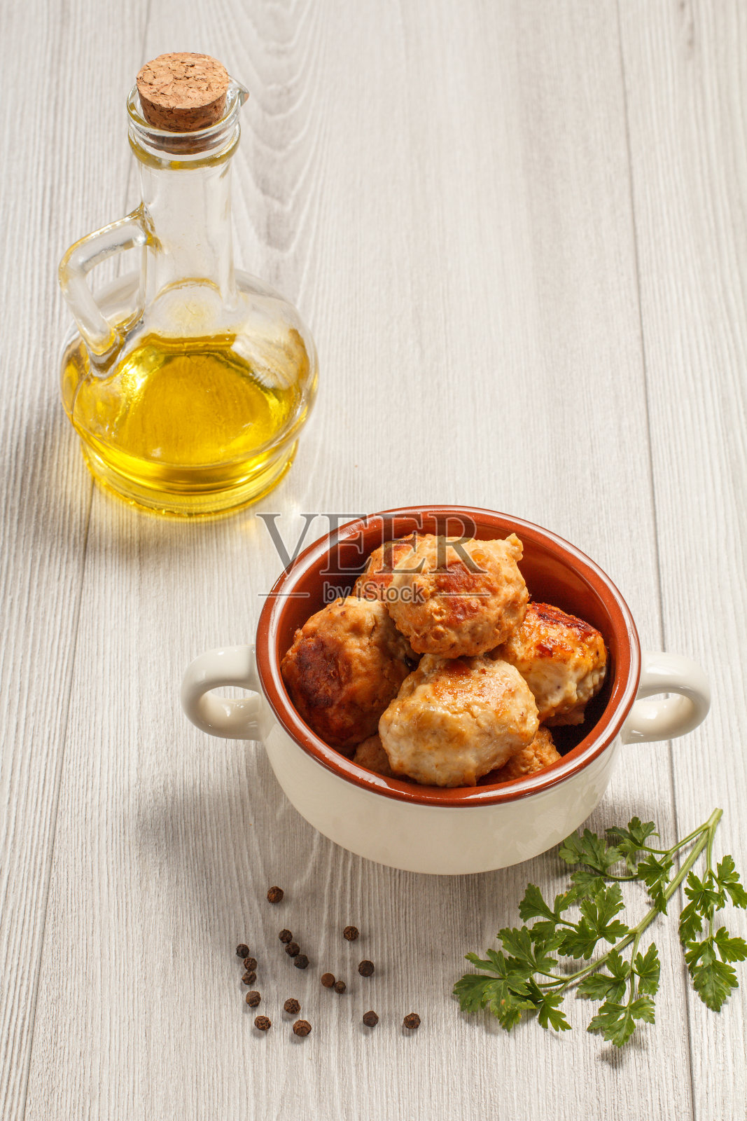 用葵花籽油将肉片放在白色陶瓷汤碗和瓶子里炸照片摄影图片