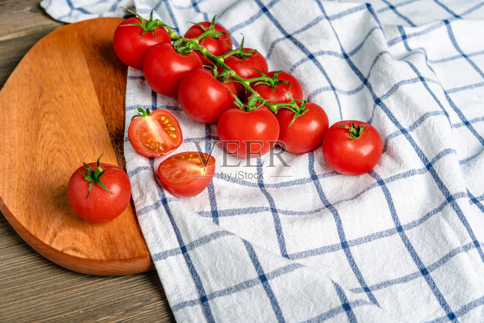 把樱桃番茄放在树枝上，放在木板上，放在厨房毛巾上照片摄影图片