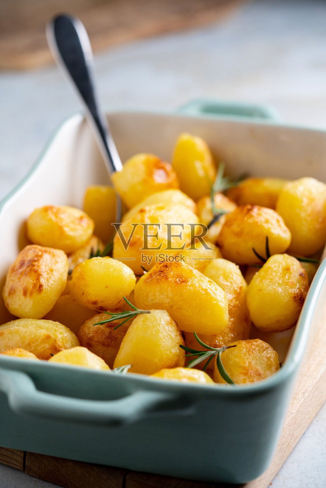 烤年轻的马铃薯与迷迭香准备吃。照片摄影图片