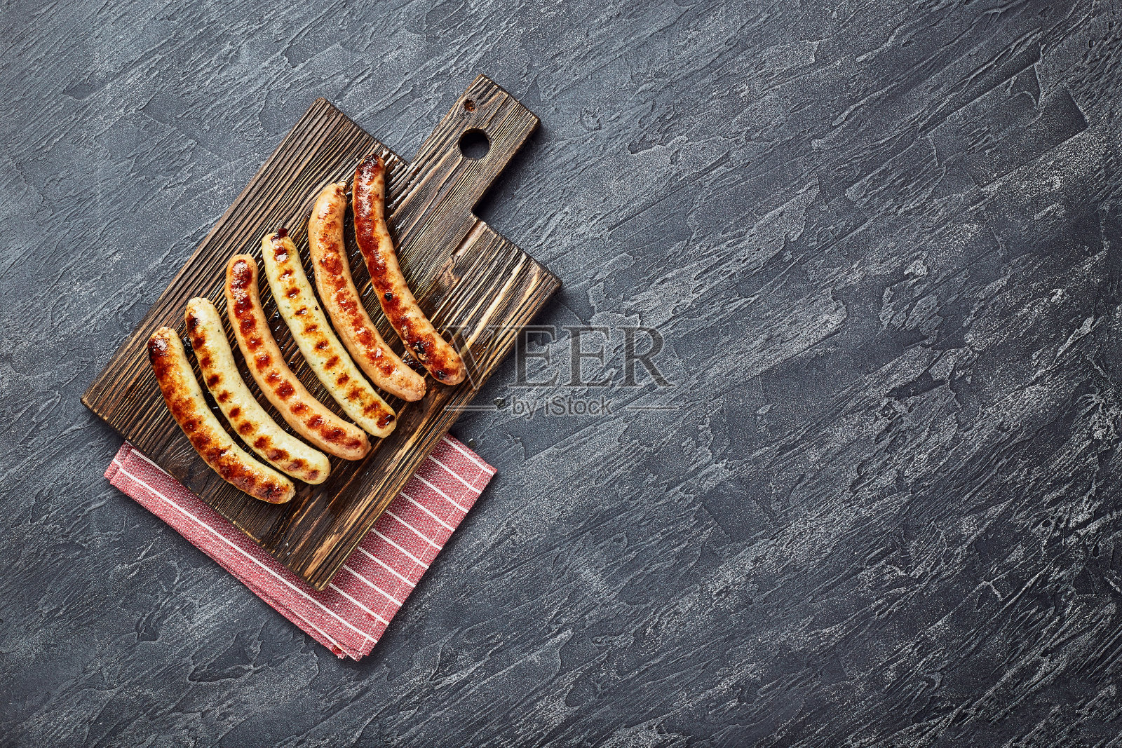 美味的烤猪肉香肠配香料和香草放在木砧板上照片摄影图片