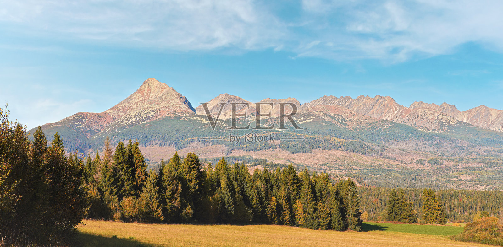 秋天的草地附近的乡村道路，全景的Tatry山与Krivak峰(斯洛伐克标志)从瓦泽克村在远处看到照片摄影图片