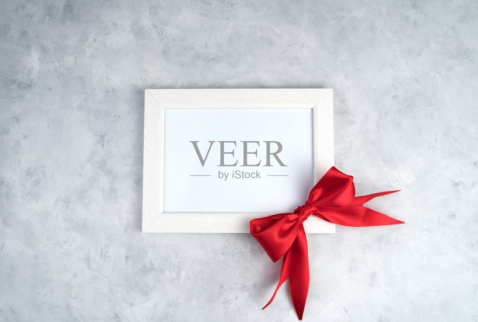 白色框架，红色蝴蝶结，灰色混凝土。照片摄影图片