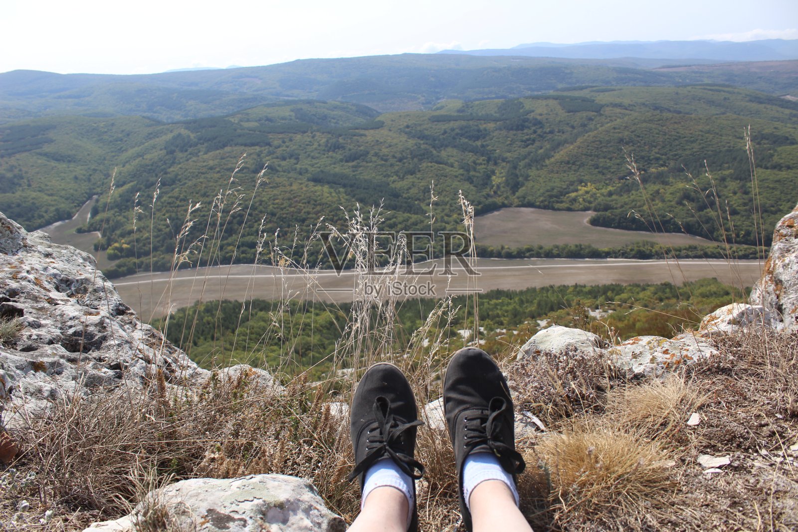 一个坐在悬崖边上的人照片摄影图片