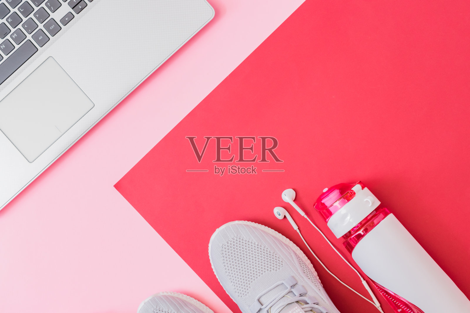 家庭在线健身概念。平铺运动鞋，新运动鞋，红色背景上的笔记本电脑照片摄影图片