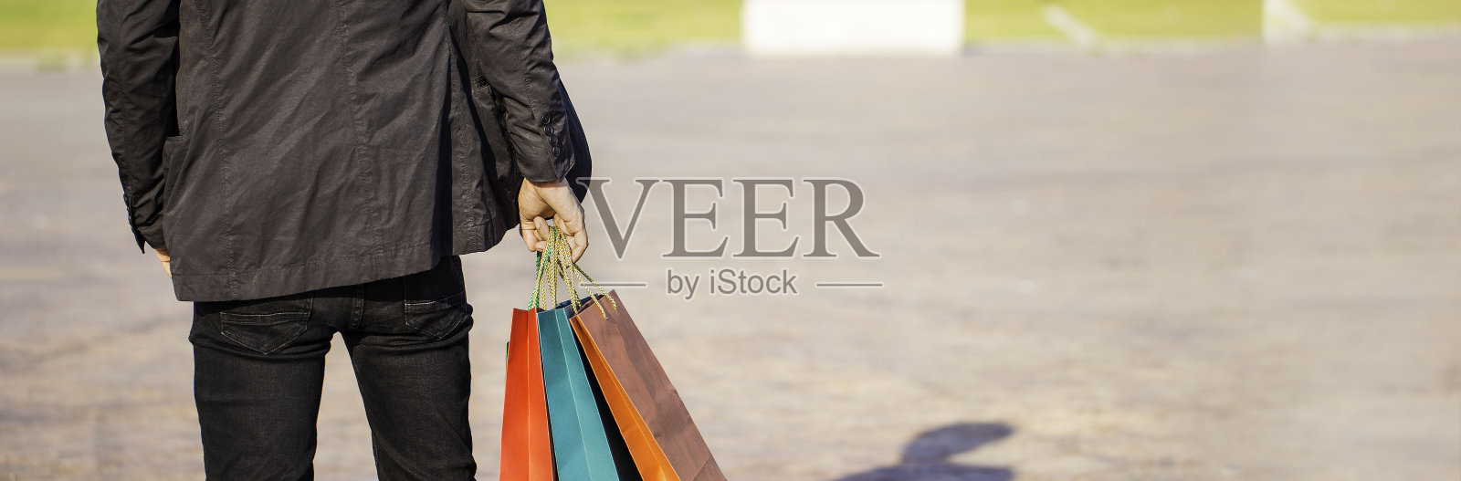 横幅背景的年轻人穿着西装拿着购物袋照片摄影图片