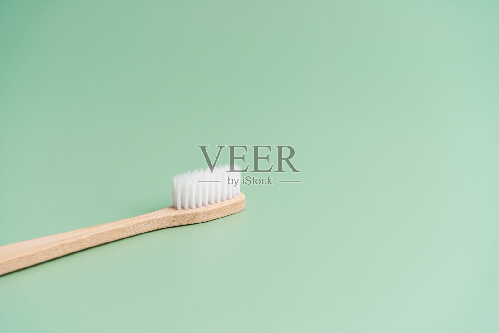 环保竹木抗菌牙刷，底色为浅绿色照片摄影图片