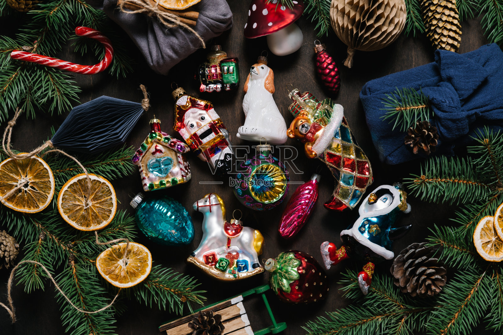 深色木桌背景上摆放着老式的圣诞玩具、云杉树枝和锥形玩具。平躺，俯视图。照片摄影图片