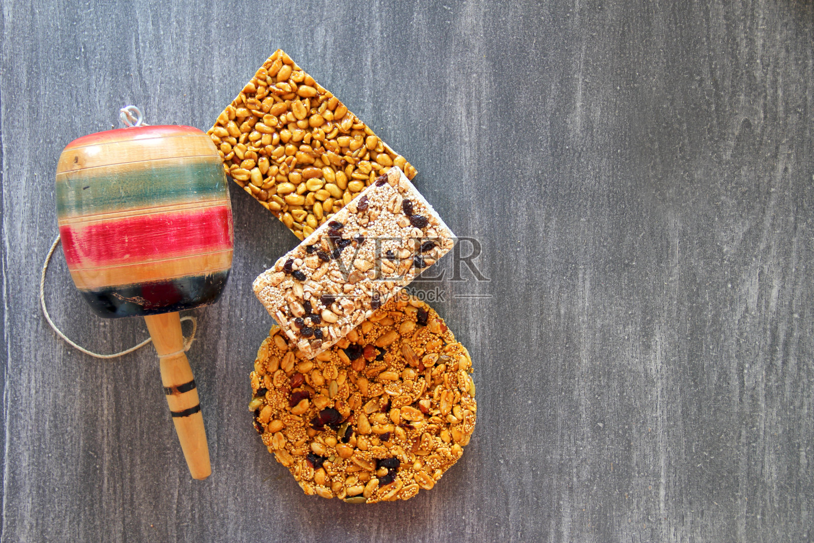 墨西哥苋菜和种子糖果与巴莱罗玩具墨西哥手工艺品在灰色的复古木制背景照片摄影图片