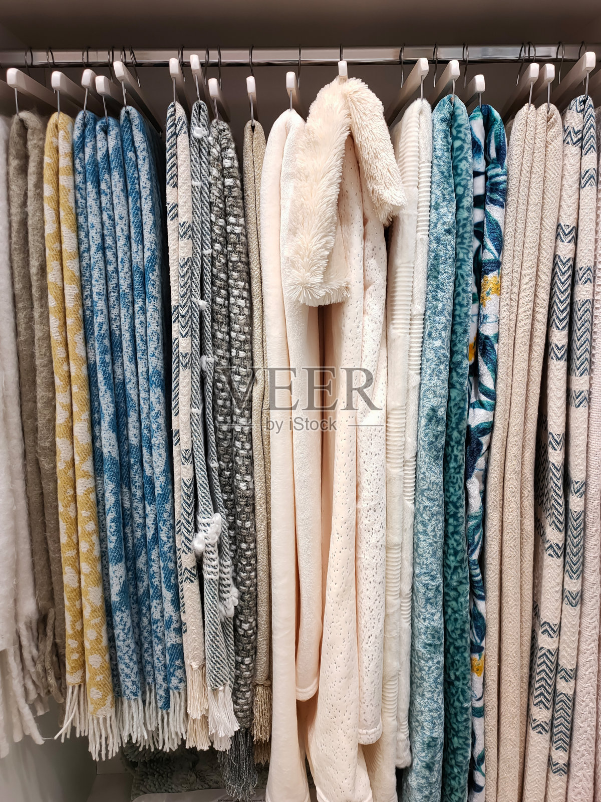 一个衣橱的视图，毛毯挂在衣架上。家的概念,生活方式照片摄影图片