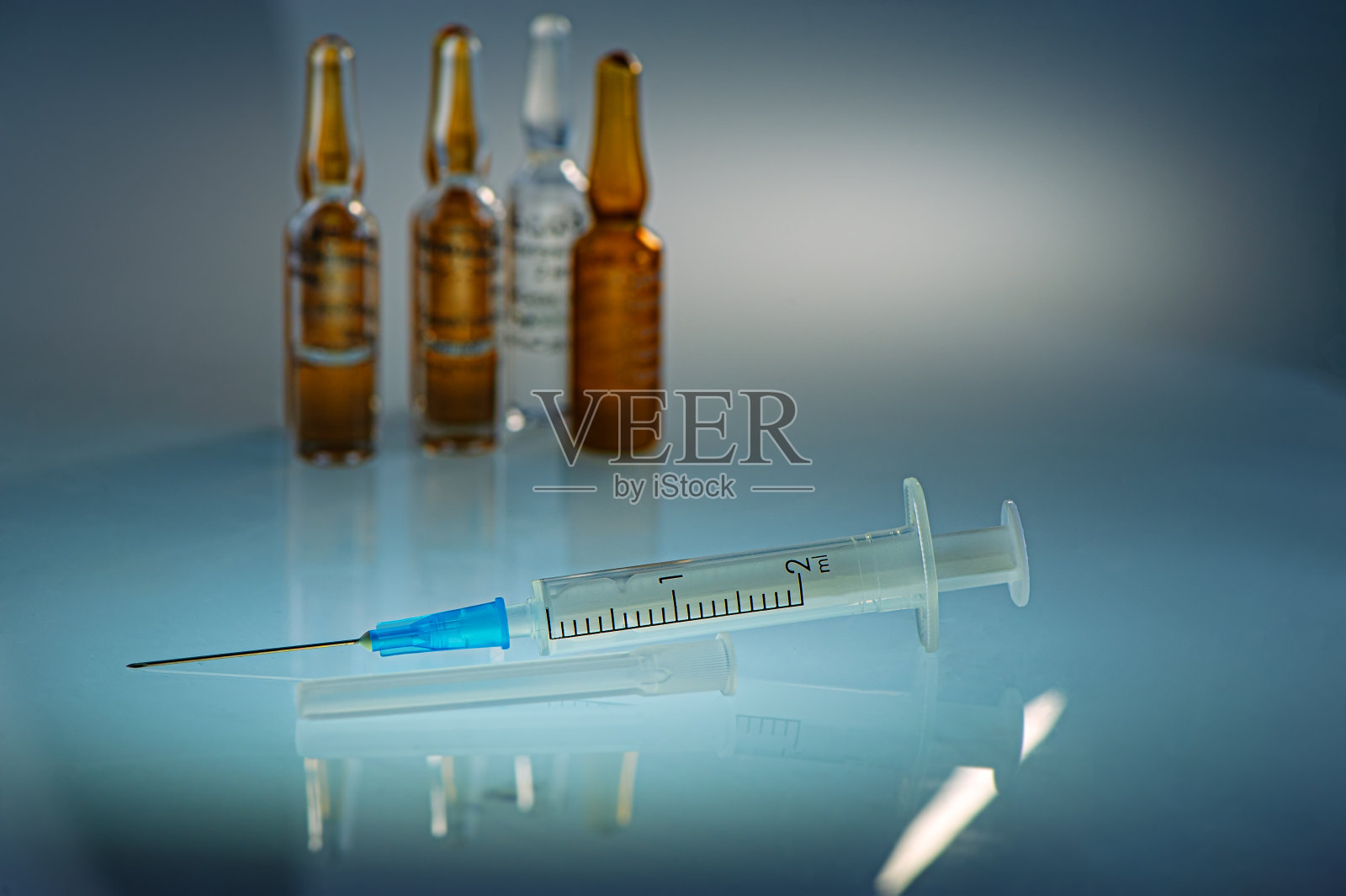 一次性注射器和疫苗瓶放在房间的桌面上。照片摄影图片