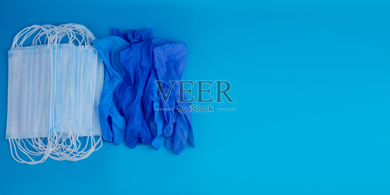 新型冠状病毒肺炎医用口罩和手套放在蓝色的背景上。健康的概念。照片摄影图片
