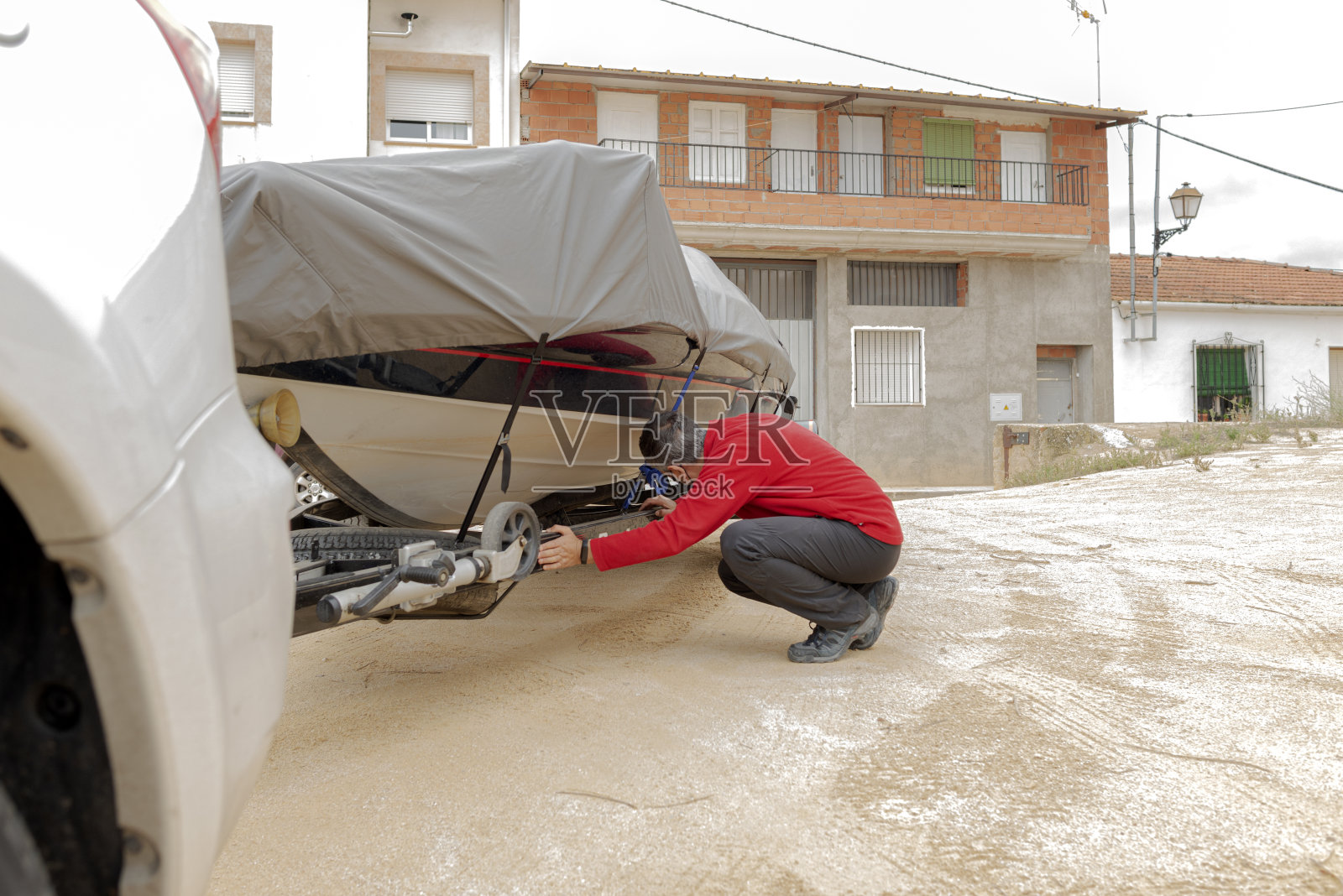 一个戴着防护面具的成年人在街上检查一艘船的带子照片摄影图片