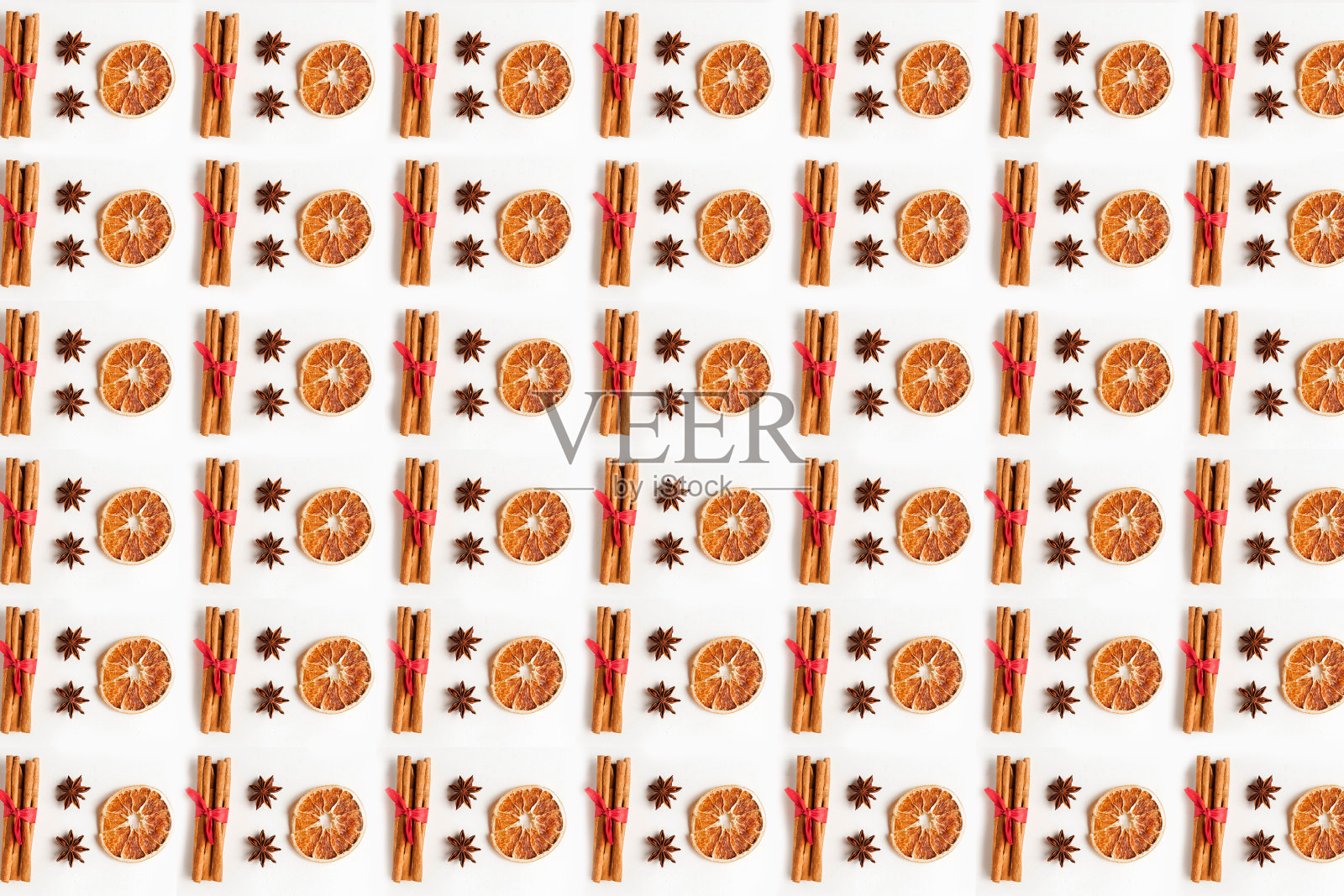 圣诞图案与肉桂，八角星和干柑橘在白色的背景。喜庆的圣诞背景。为文本复制空间。圣诞贺卡模板照片摄影图片