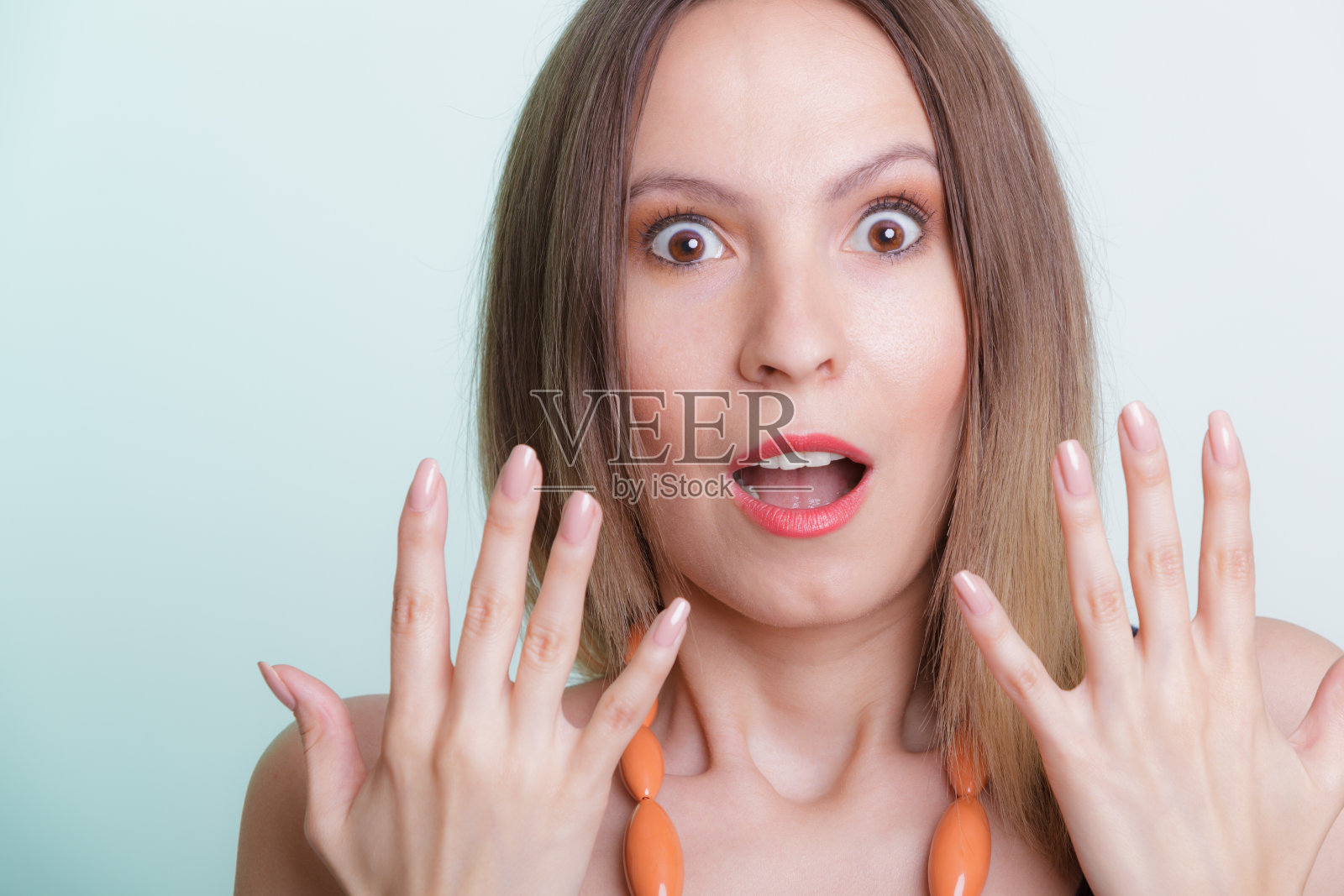 惊讶的女孩眼睛睁得大大的，做着手势照片摄影图片