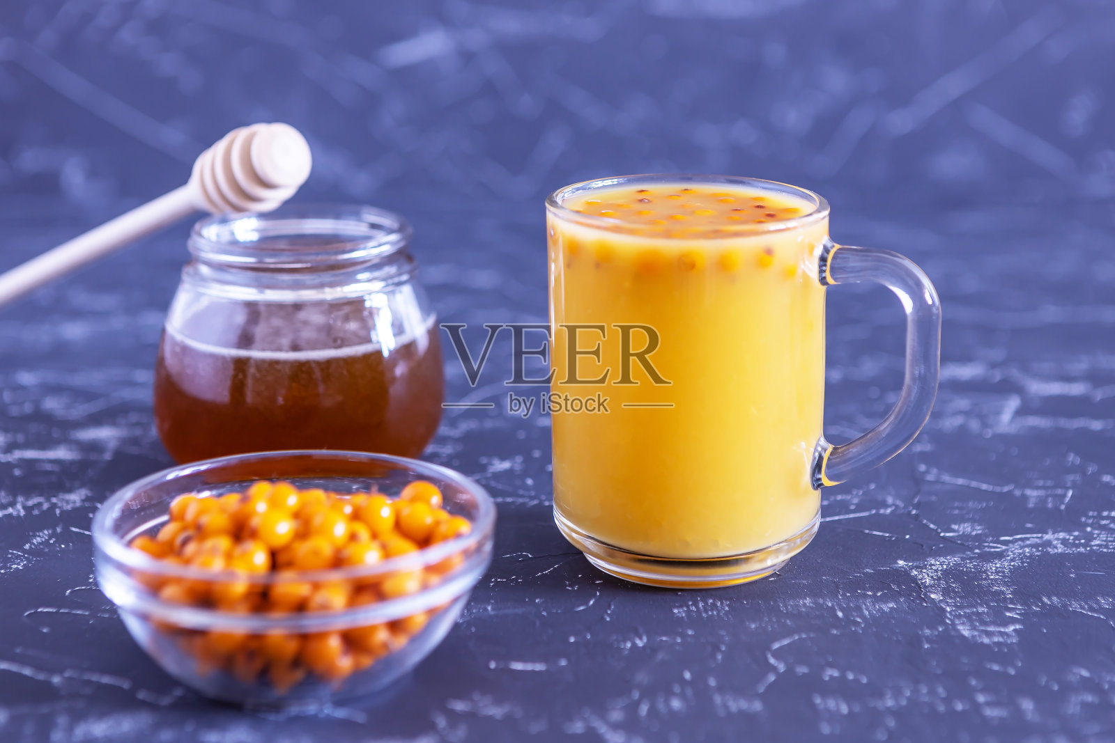 沙棘汁和蜂蜜在黑色的背景。替代医学照片摄影图片