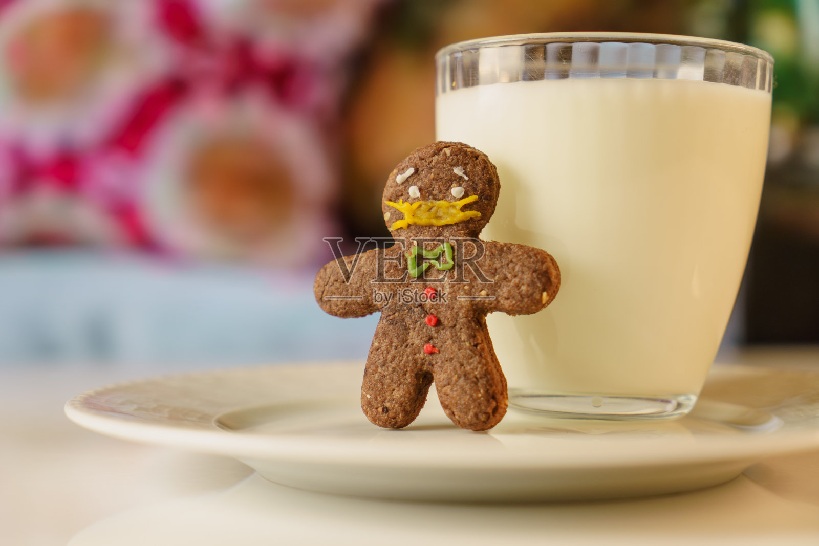 covid-19主题饼干。看起来像戴了防护面具的饼干。姜饼戴着医用口罩咖啡桌上放着一块饼干和一杯牛奶。待在家里，保持社交距离照片摄影图片