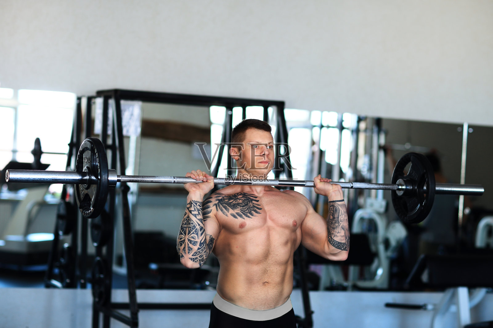 健美运动员在健身房里练杠铃照片摄影图片