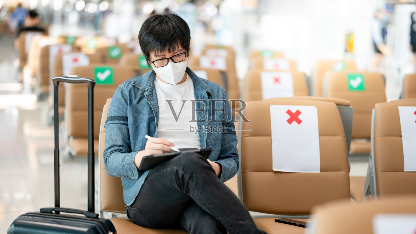亚洲男子游客在机场航站楼使用平板电脑照片摄影图片