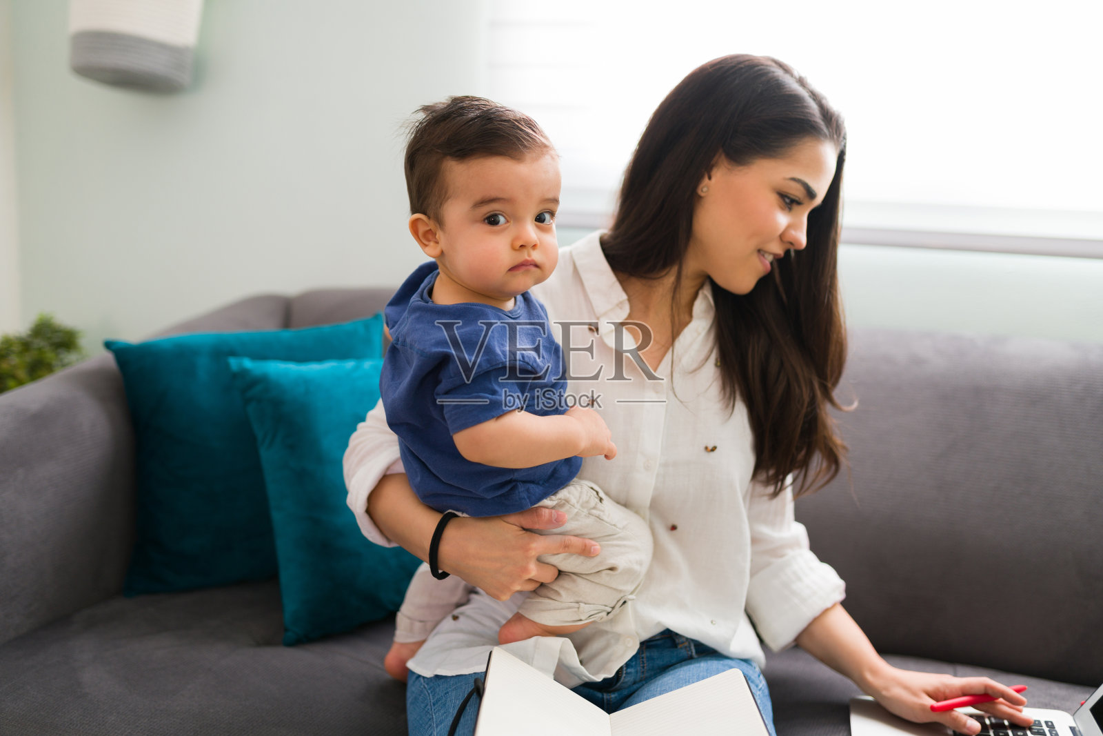 年轻母亲在家工作带着儿子照片摄影图片