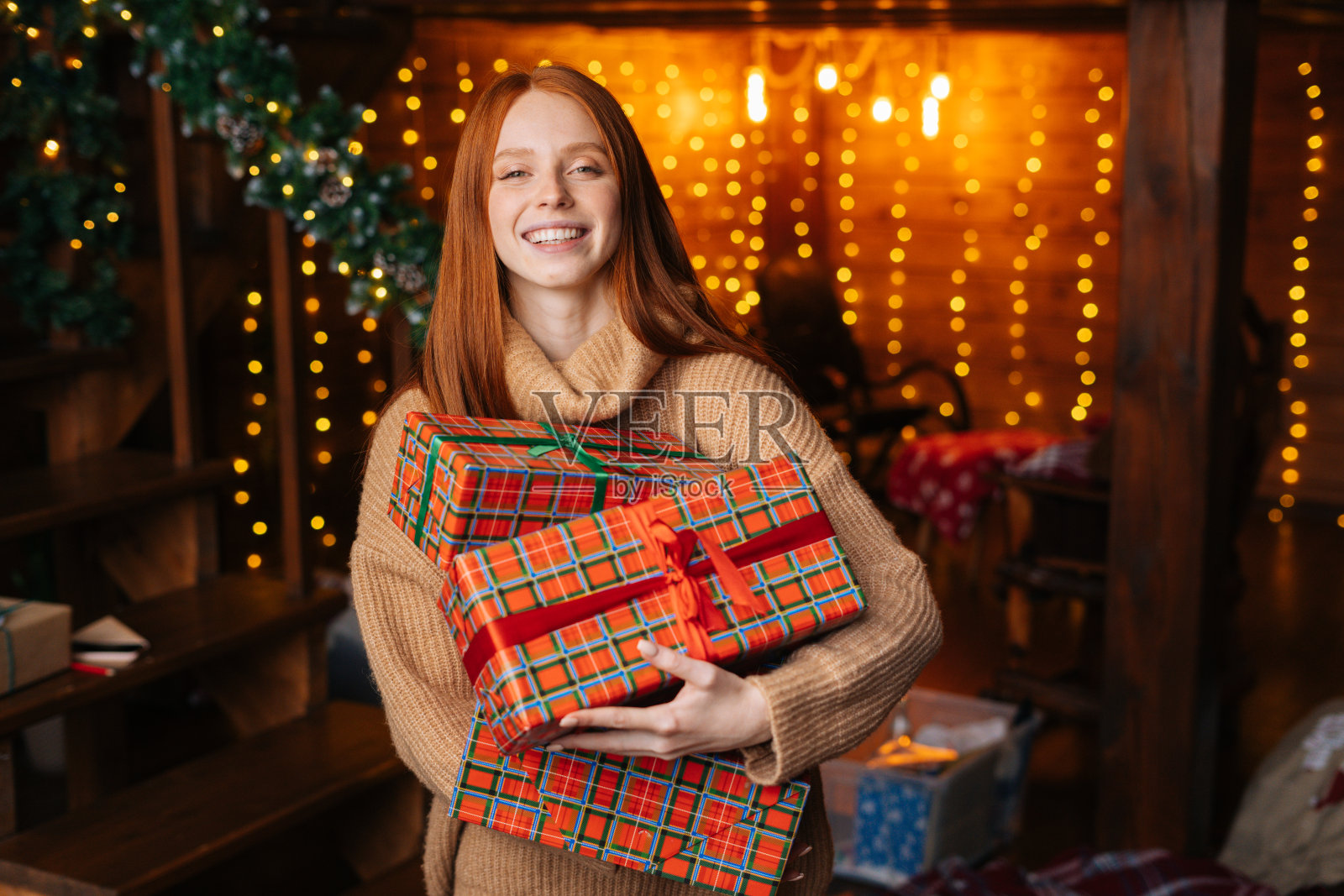 特写的快乐红发年轻女子抱着许多美丽的圣诞礼物盒照片摄影图片