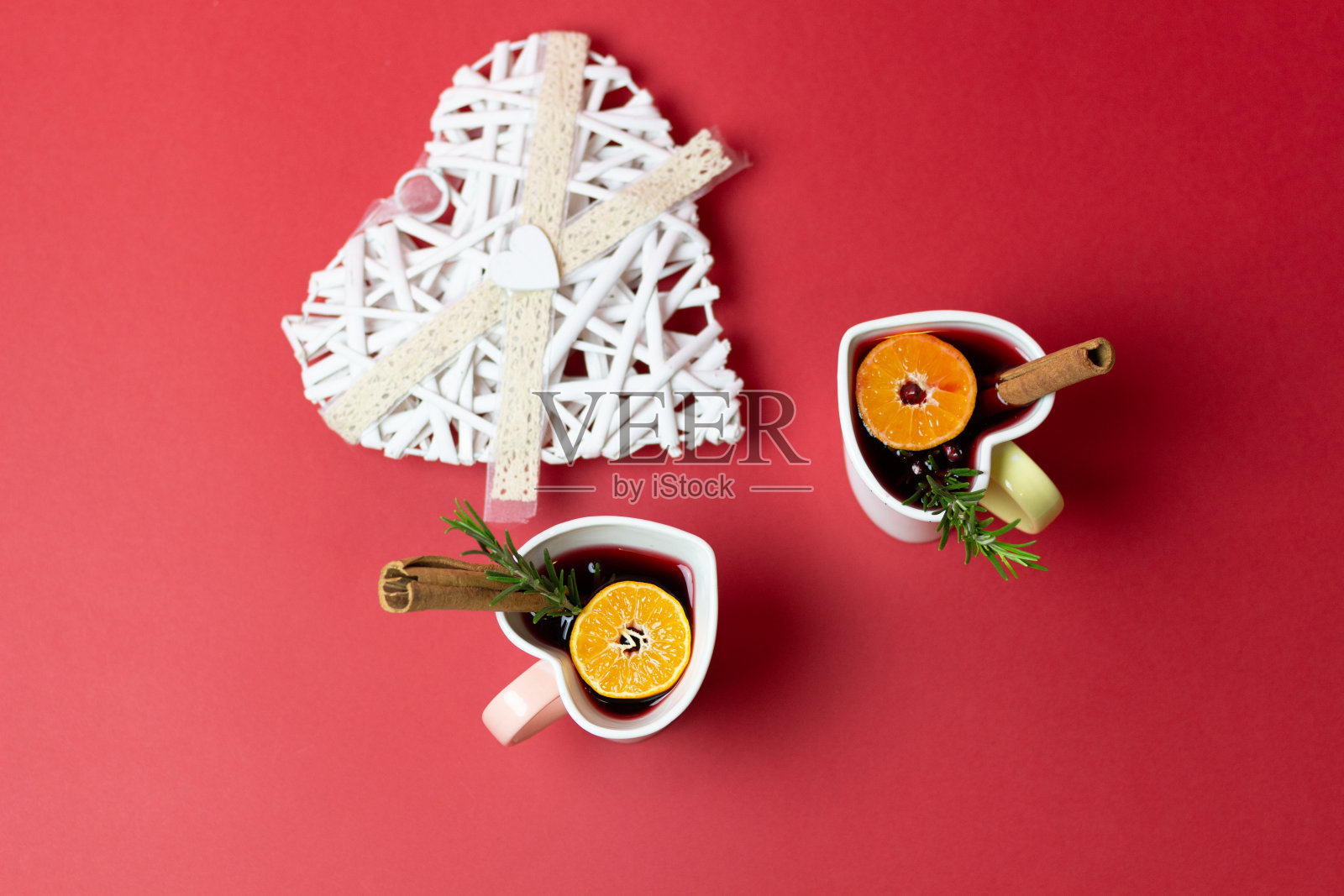 心形杯与香料和橘子热葡萄酒在红色背景照片摄影图片