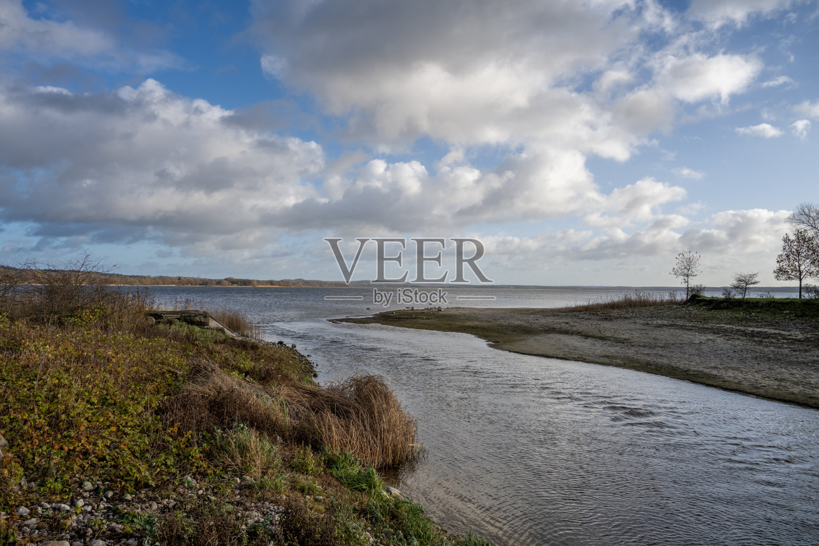 从一个湖泊的河流出口与一个戏剧性的天空在背景。图片来自瑞典斯卡尼亚的呕吐湖照片摄影图片
