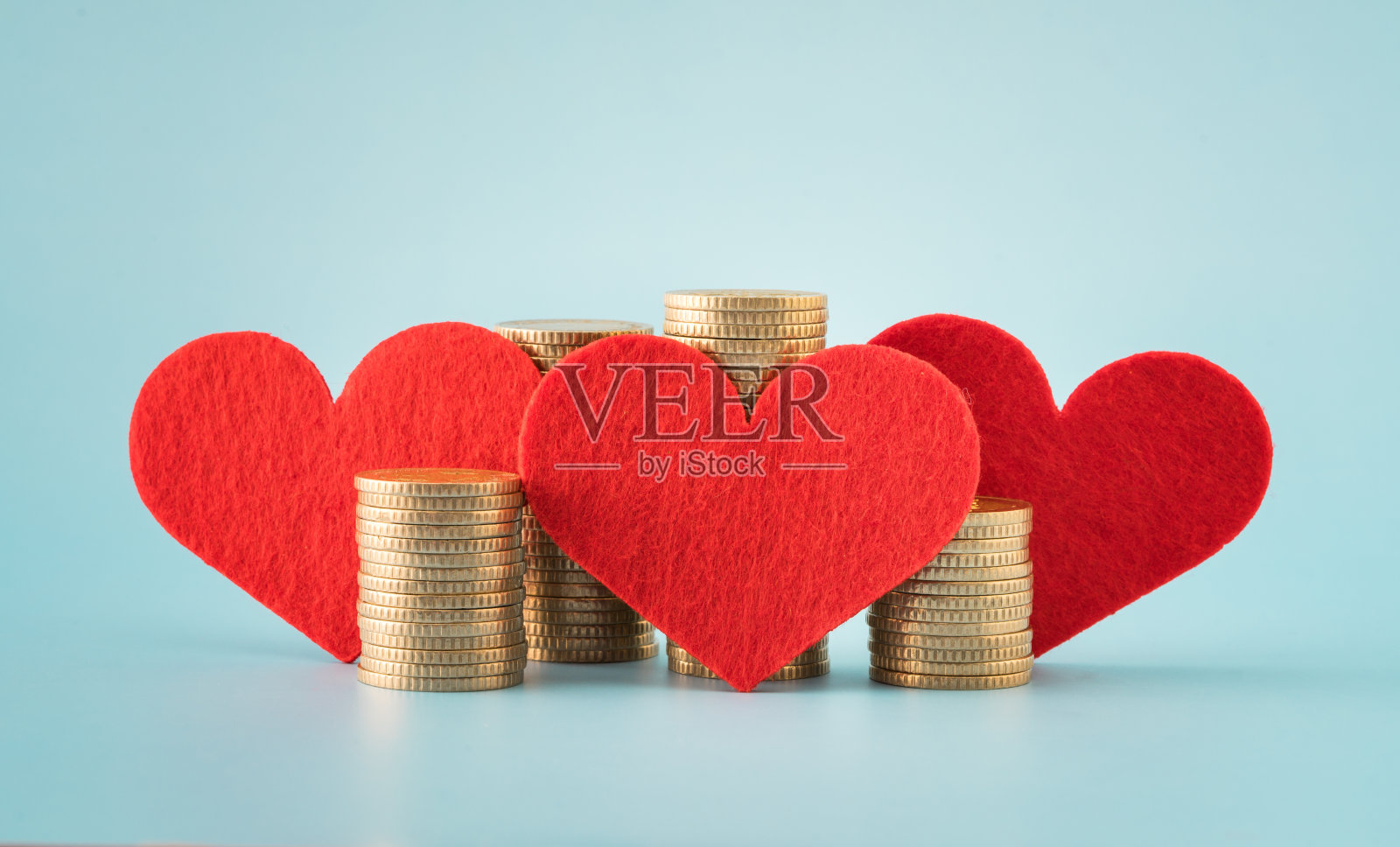 硬币堆和蓝色背景上的心照片摄影图片
