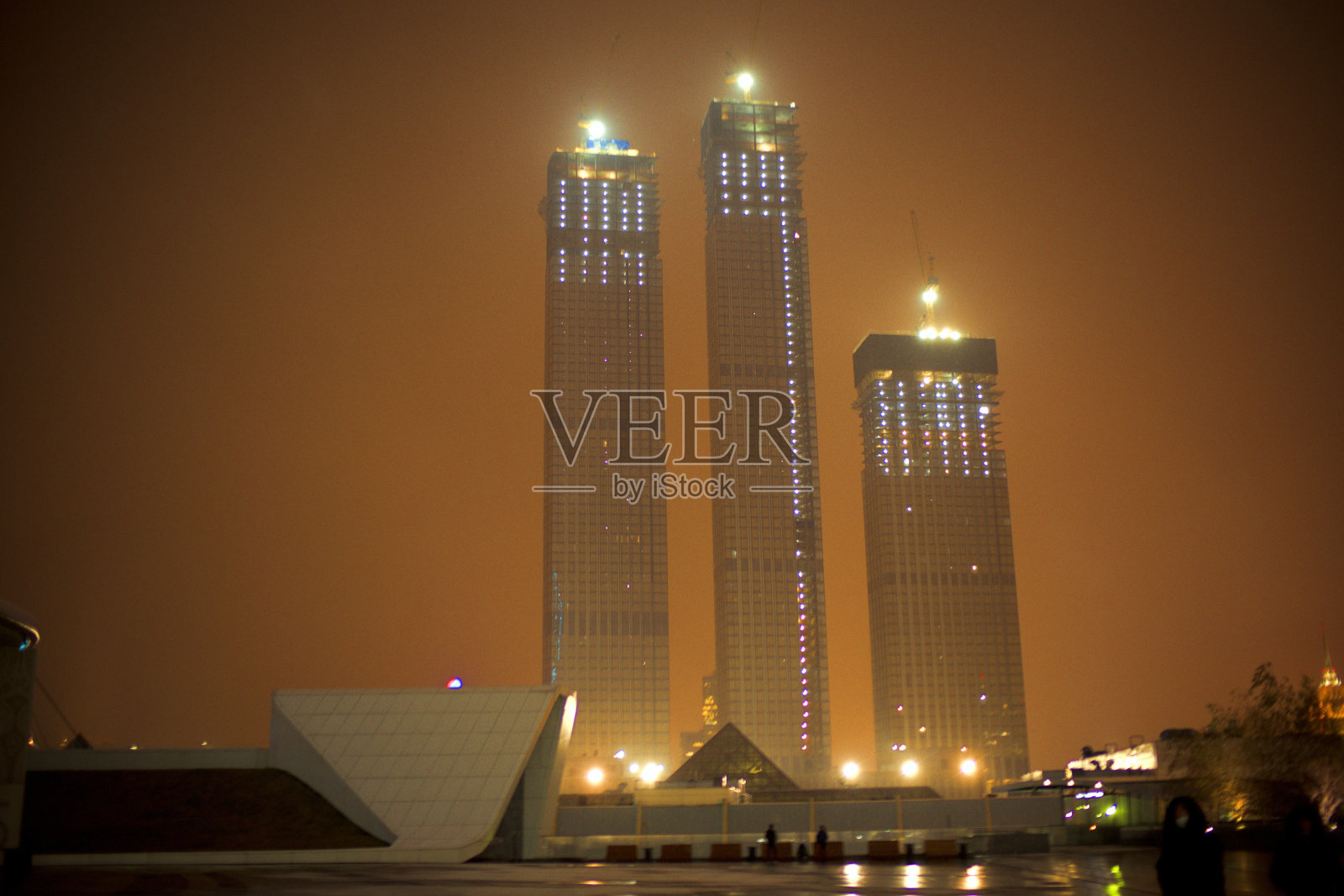 在夜间建造高层建筑。夜间施工。照片摄影图片