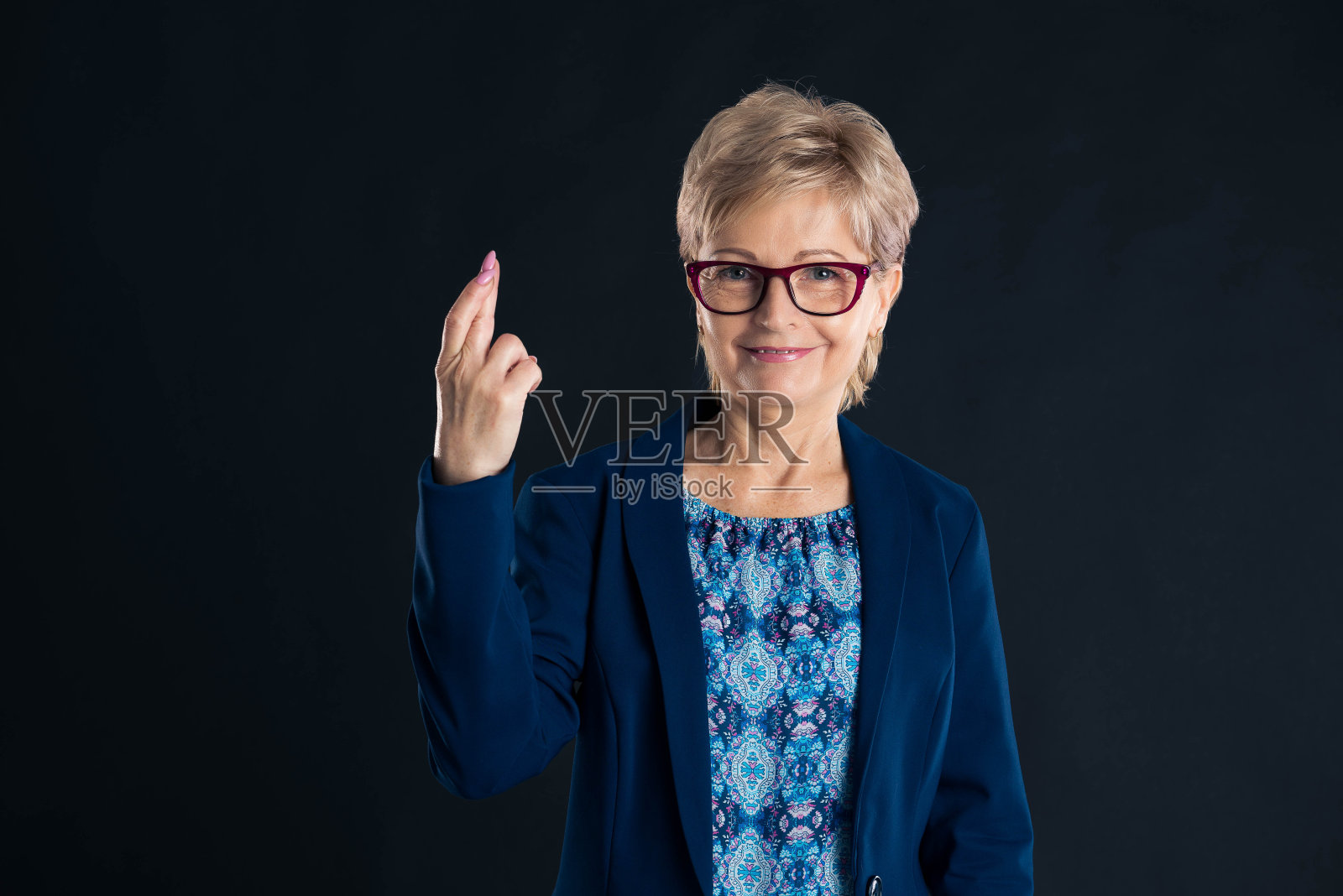 年长的秘书显示好运的迹象照片摄影图片