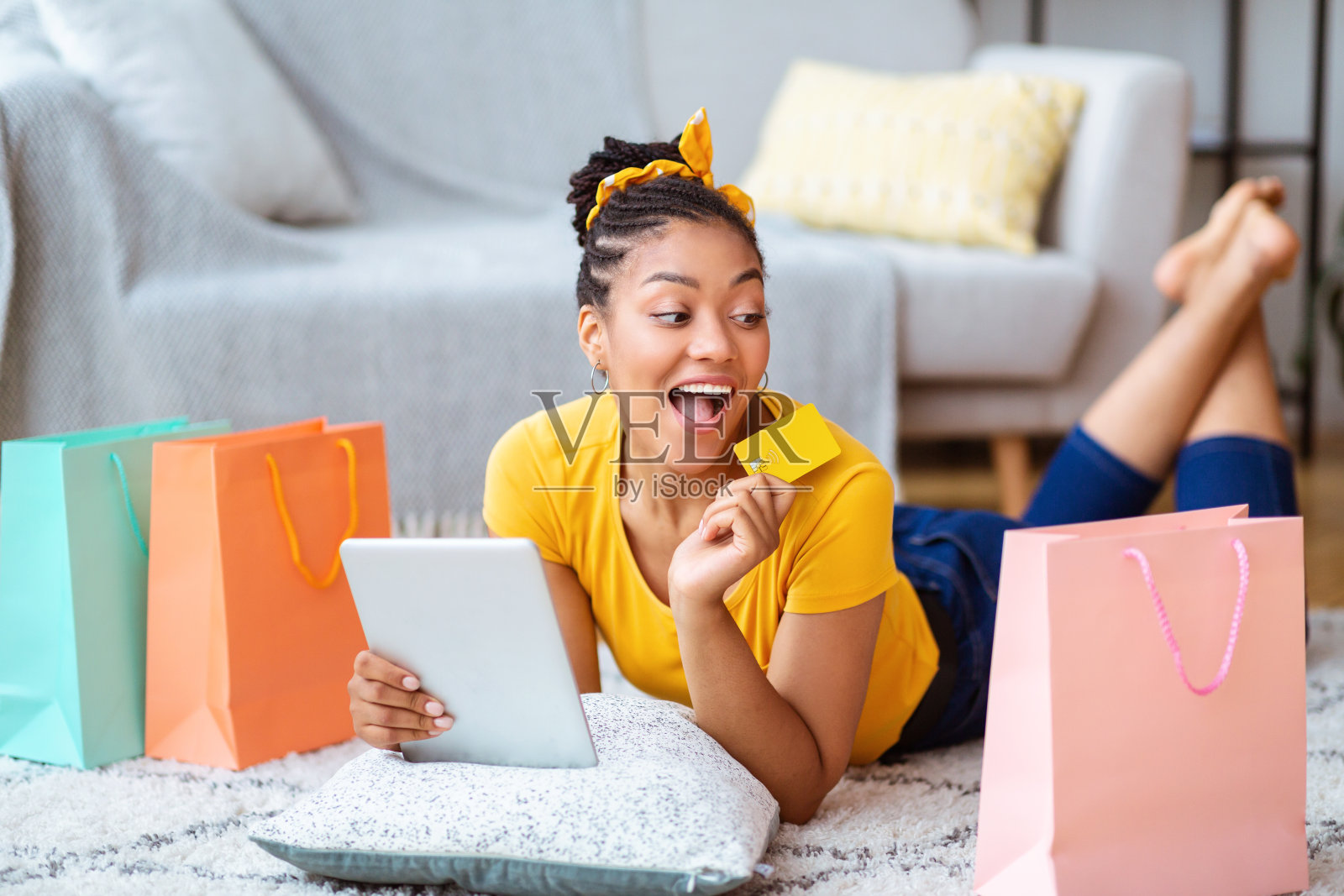 黑人女性在家里使用平板电脑和信用卡照片摄影图片