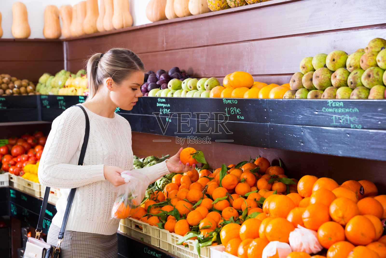 兴高采烈的女顾客在超市里拿着新鲜水果照片摄影图片