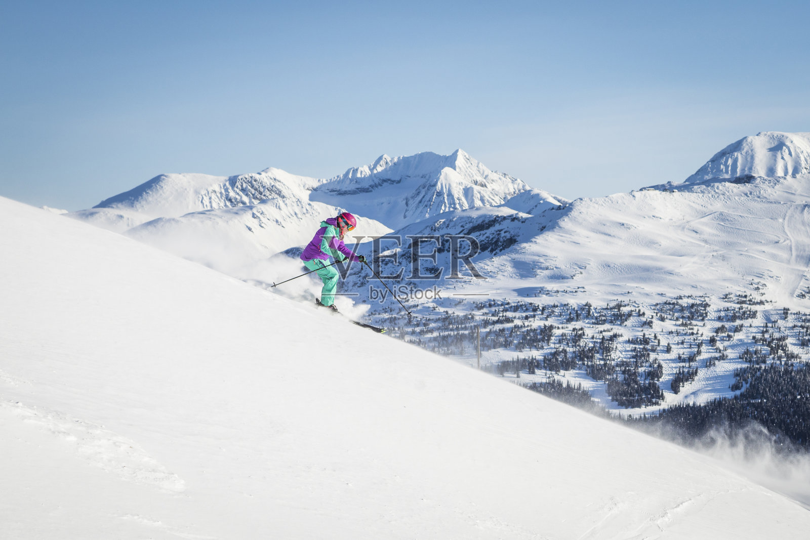 在阳光明媚的日子里，在平整的滑雪道上滑雪的女人照片摄影图片