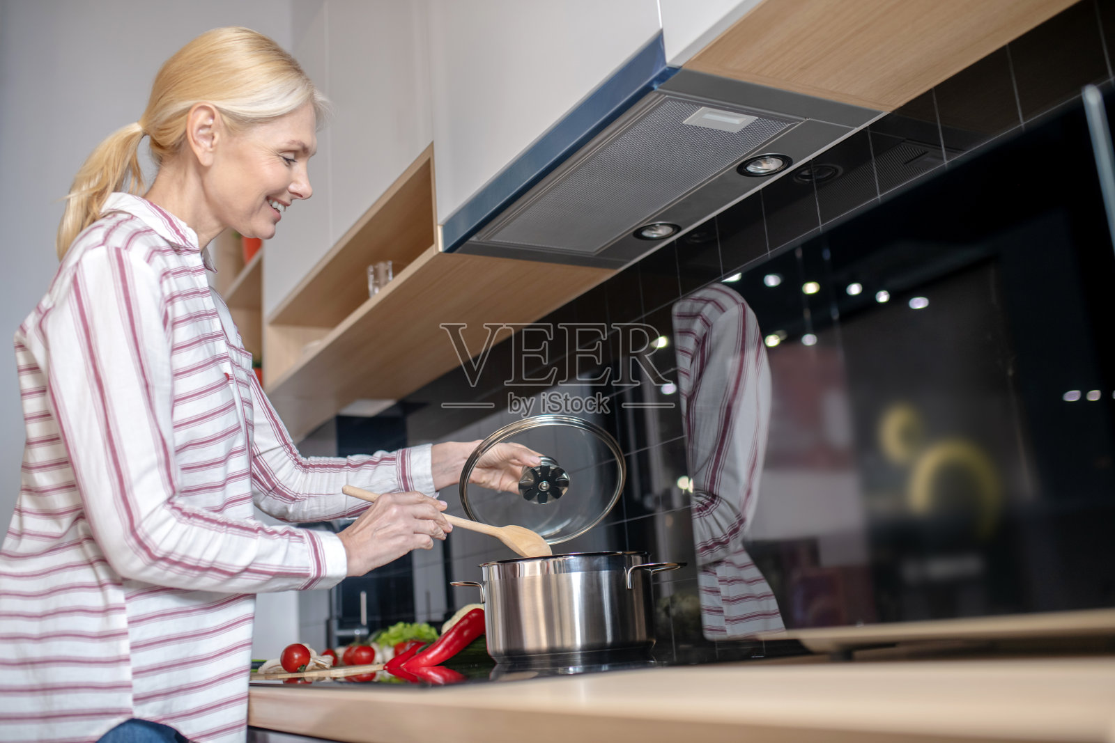 金发女人在厨房做饭，感觉很好照片摄影图片