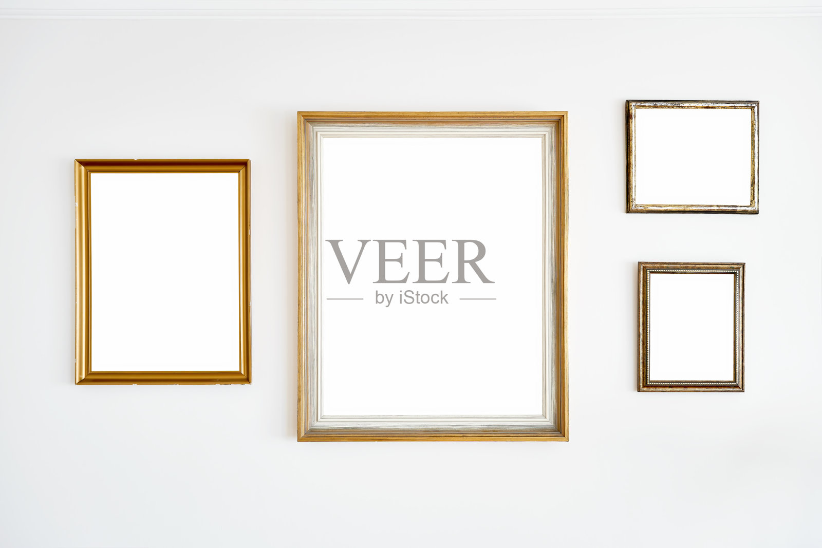 白墙上挂着老式的金色空框照片摄影图片