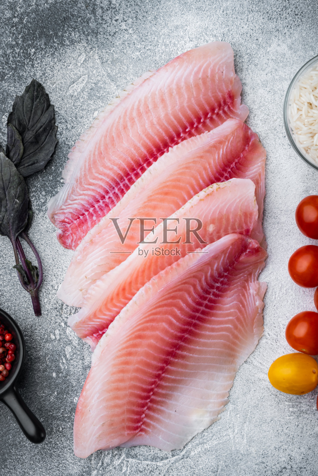 白鱼片配印度香米和樱桃番茄，灰色背景，俯视图照片摄影图片