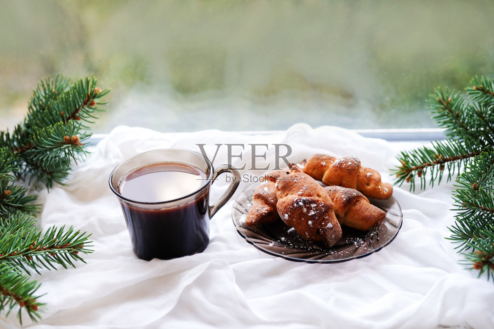 冬天的热咖啡与牛角面包和圣诞冷杉树枝的背景-乡村静物生活，冬天的早晨照片摄影图片