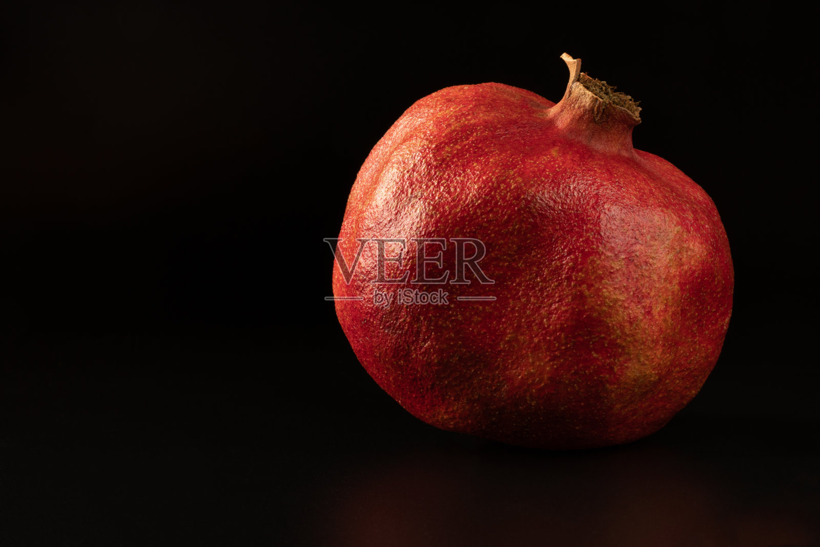 孤立的红石榴特写在黑色的背景。健康的蔬菜的概念。照片摄影图片