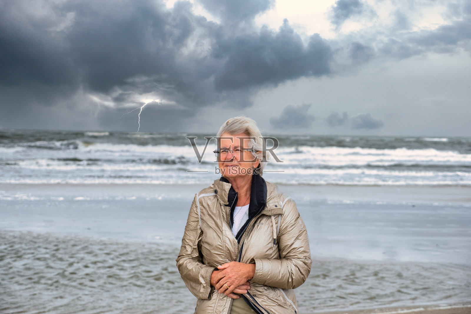 高级白种女人在海滩与史诗暴风雨的天空背景照片摄影图片