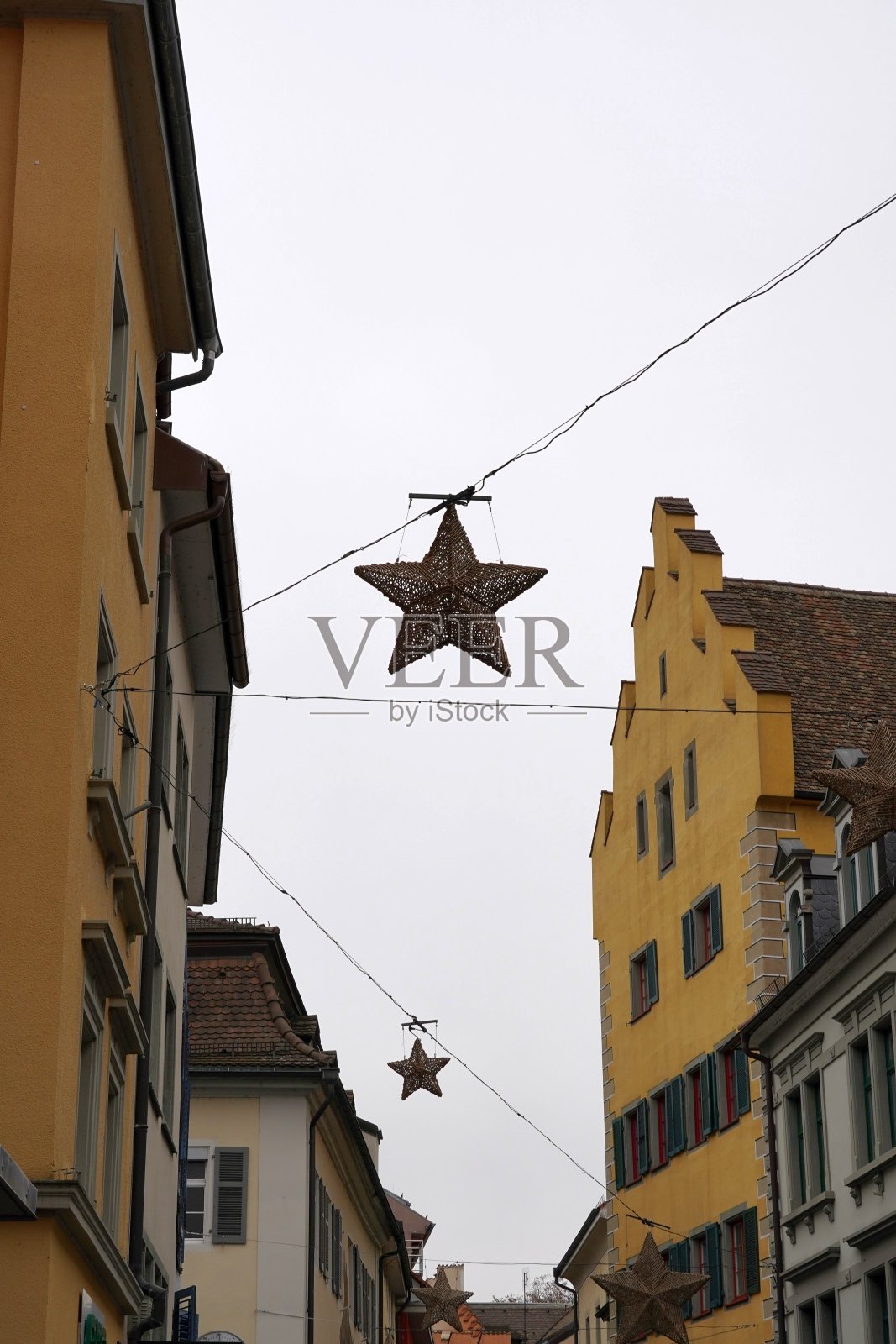 德国康斯坦斯市的圣诞装饰。古老的城市里，历史建筑之间挂着星星。照片摄影图片