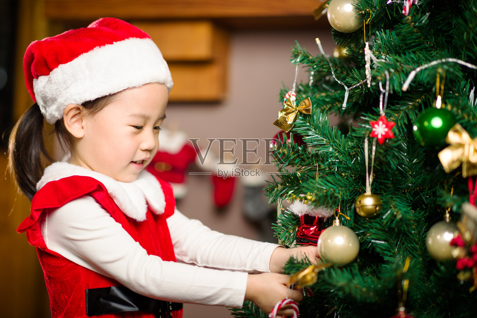 小女孩在家里装饰圣诞树照片摄影图片