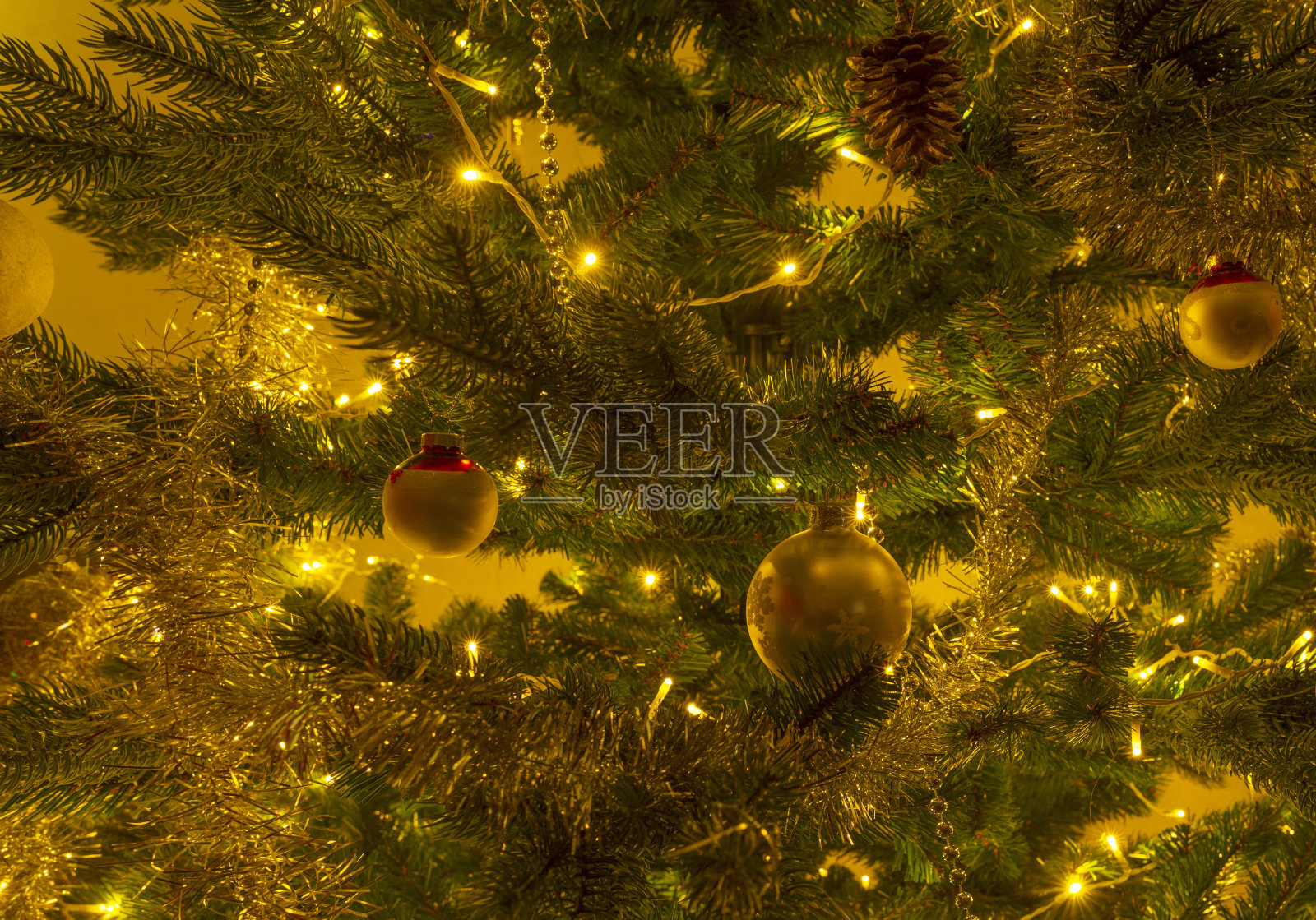 装饰照明的圣诞树在室内用灯和花环照片摄影图片